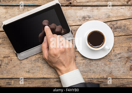 Businessman à la pause café à l'aide de Tablet PC. Lieu de travail à distance sur un bureau en bois. Vue supérieure de la maquette d'affaires Banque D'Images