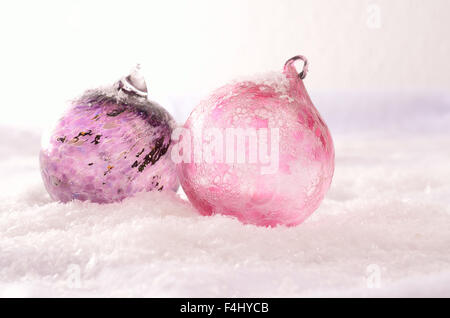 Boules de Noël en verre rose dans la neige Banque D'Images