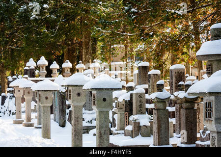 Le Japon, Koyasan, célèbre cimetière Okunoin. Mémoriaux grave derrière aux lanternes en pierre, piédestal ishidoro, garnitures de voie. L'hiver. Banque D'Images