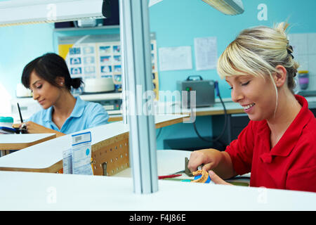 Technicien dentaire dentiers de broyage dans un laboratoire dentaire Banque D'Images