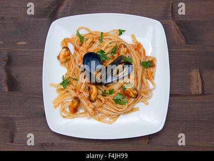 Pâtes aux moules sur la plaque sur une table en bois Vue de dessus Banque D'Images