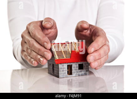 Mains près de façon protectrice autour d'un nouveau bâtiment. Banque D'Images