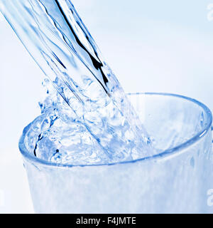 Détail de l'eau potable qui est versé dans un verre. Banque D'Images