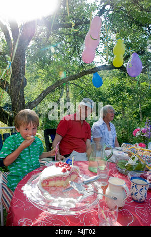 Boy eating cake at Birthday party Banque D'Images