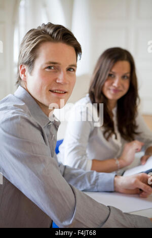 Portrait de jeune homme et femme assis côte à côte lors de la rencontre Banque D'Images