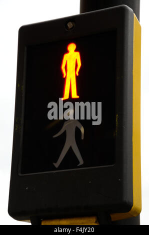 Un homme rouge montre sur un passage pour piétons. Banque D'Images