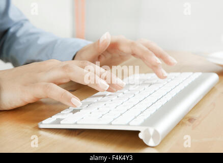 Les doigts de taper sur un clavier à un bureau, pas de visage Banque D'Images