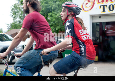 Attractive young couple âge 25 équitation un vélo construit pour deux portant des T-shirt avec de grosses étoiles sur le manchon St Paul Minnesota MN USA Banque D'Images