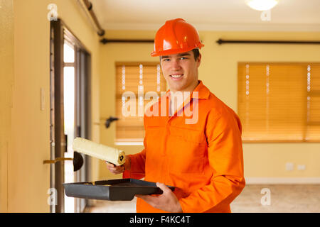 Happy construction worker painting the wall in new house Banque D'Images