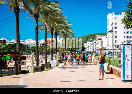 Les gens qui marchent le long de la promenade maritime bordée de palmiers en bord de mer à sunny day Banque D'Images
