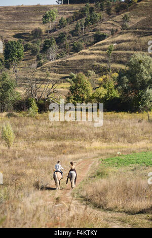 Jeune couple amoureux équitation Banque D'Images