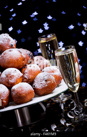 "Oliebollen", des pâtisseries pour le nouvel an et deux verres de champagne. Banque D'Images