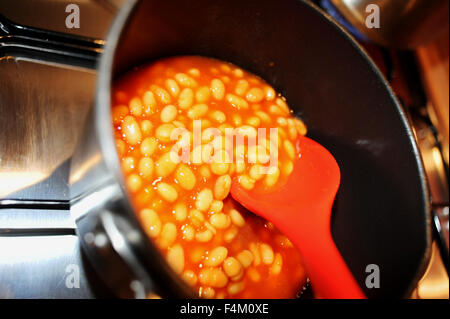 Les haricots cuits sont réchauffés dans une casserole sur une table de cuisson à gaz Banque D'Images