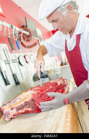 Butcher est qualifié dans la préparation de la viande Banque D'Images