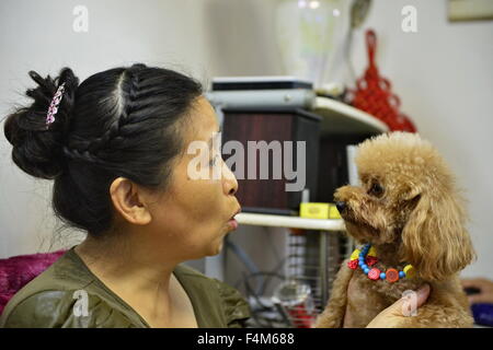 Beijing, Chine, province de Jiangxi. 25 Septembre, 2015. 58-year-old Yanlin Liu parle à son chien nommé Liuxiaoniu à Nanchang, capitale de la province de l'est de la Chine, 25 Septembre, 2015. D'ici la fin de 2014, le nombre de la population au-dessus de hauts chinois 60 ans était de 212 millions de dollars, soit environ 15,5 pour cent de la population totale du pays. De nos jours, de plus en plus de personnes en Chine préfèrent élever les animaux qui ont fait leurs preuves pour apporter une contribution positive à la vie de personnes âgées. © Zhou Mi/Xinhua/Alamy Live News Banque D'Images