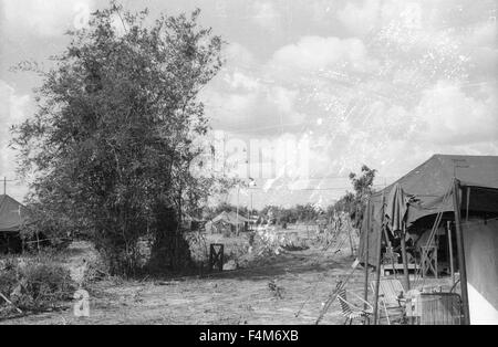 Tentes lors d'une Première Division d'infanterie, camp de base en 1965 pendant la guerre du Vietnam. Huey hélicoptères volant à distance Banque D'Images