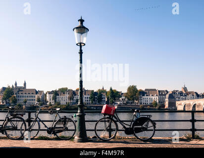 Les vélos enchaînés à une clôture en face de Meuse, scène néerlandaise, Maastricht, Limbourg, Pays-Bas. Banque D'Images