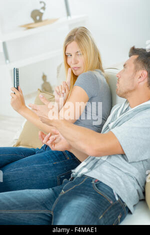 Couple fighting over la télécommande du téléviseur Banque D'Images