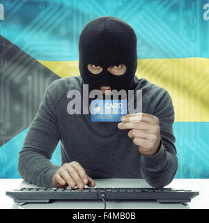 La peau sombre pirate avec carte de crédit en main et d'un drapeau sur fond - Bahamas Banque D'Images