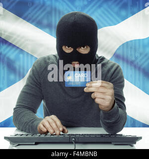 La peau sombre pirate avec carte de crédit en main et d'un drapeau sur fond - Ecosse Banque D'Images