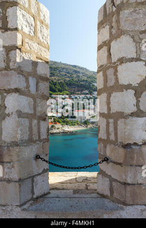 Vue de l'océan et la ville à travers une brèche dans les murs de la ville de Dubrovnik, Croatie. Banque D'Images