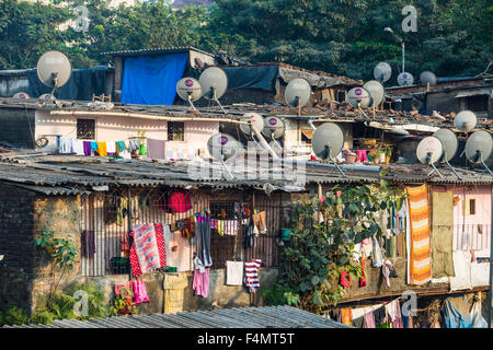 Un bidonville avec des maisons faites de tôle ondulée et de nombreux plats de télévision sur leurs toits Banque D'Images