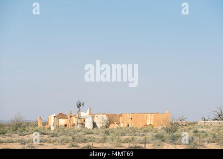 Un moulin à vent et les ruines dans un paysage typique du Karoo, dure près de Vanwyksvlei dans la province du Cap du Nord de l'Afrique du Sud Banque D'Images