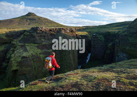 Randonneur à côté de la partie supérieure de la rivière Skoga, Fimmvorduhals trail, Sudhurland, Islande. Banque D'Images