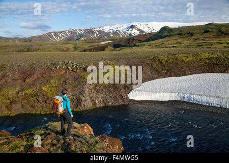 Randonneur à côté de la rivière Skogar avec ci-dessus, Eyjafjallajokull, Sudhurland Fimmvorduhals trail, de l'Islande. Banque D'Images