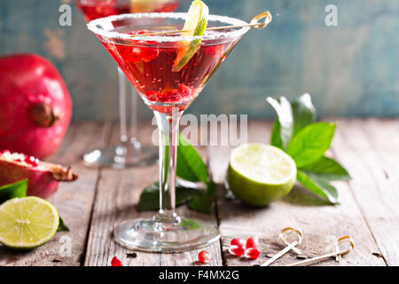 Pomegranate martini avec tranches de lime et de graines de grenade Banque D'Images