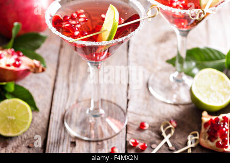 Pomegranate martini avec tranches de lime et de graines de grenade Banque D'Images