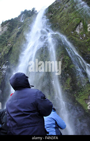 Tourist photographing Stirling Falls, Milford Sound, Fiordland, Nouvelle-Zélande Banque D'Images