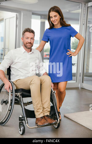 L'homme en fauteuil roulant avec son amie, souriant joyeusement Banque D'Images