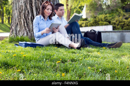 L'herbe et de fleurs et de deux personnes lisant Banque D'Images