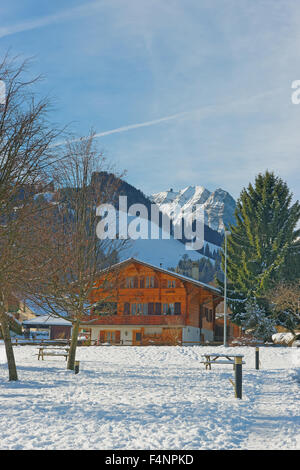 Paysage d'hiver ensoleillé avec un chalet alpin. Le Gruyère, province de Fribourg, Suisse Banque D'Images