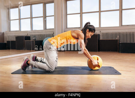 Young woman exercising with électrique Bell dans la salle de sport. Ce modèle féminin de remise en forme d'entraînement Crossfit au club de santé. Banque D'Images