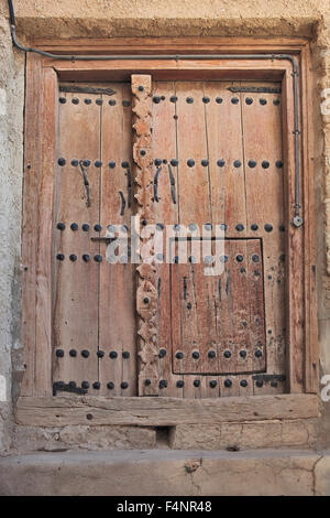 Vieille porte en bois dans la cour, fort courage Muscat, Oman Banque D'Images