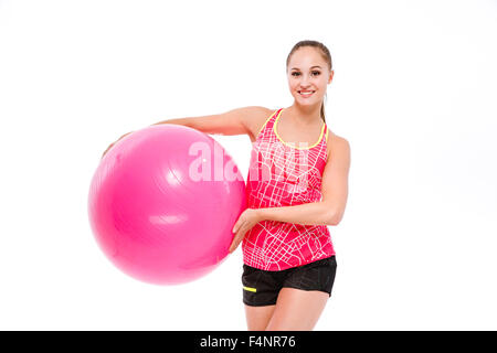 Young smiling belle grande sportive en rose top et short noir fitball holding Banque D'Images