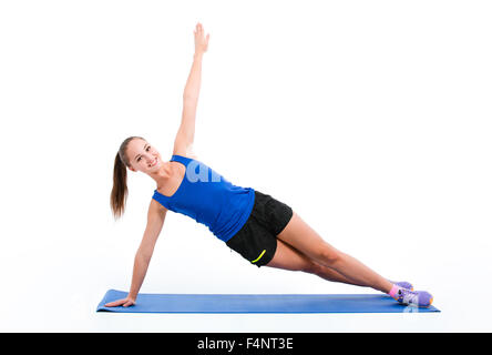 Portrait of a happy woman doing yoga fitness exercices sur le tapis isolé sur fond blanc Banque D'Images