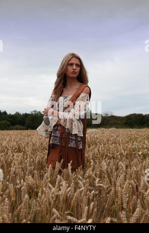 Teenage girl dans un pré à la triste avec des moody sky Banque D'Images