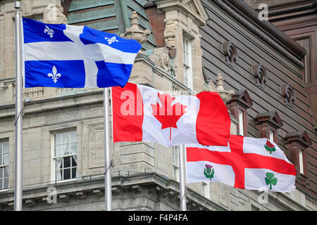 Québec et Montréal, les drapeaux flottant à l'avant-plan de l'Hôtel de Ville de Montréal, Québec, Canada Banque D'Images