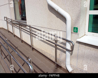 Rampe pour handicapés avec rampe en métal à l'avant pour un immeuble de bureaux dans la journée d'été ensoleillée Banque D'Images