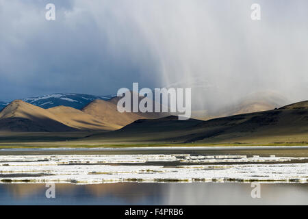 Couches de sel, paysage aride et sombres nuages chez Tso Kar, un lac salé situé à une altitude de 4,530 m au-dessus de se Banque D'Images