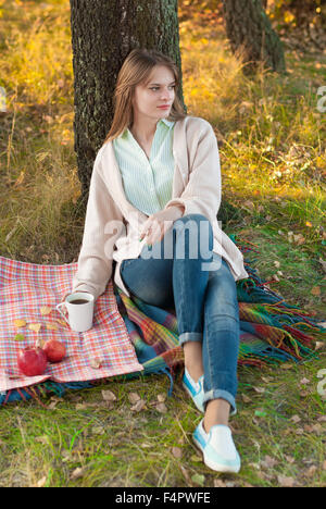 Jeune fille belle de vous détendre dans le parc de l'automne. Banque D'Images