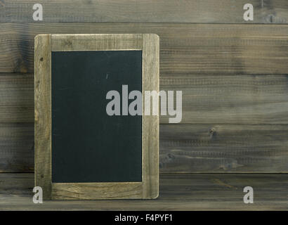 Tableau noir sur fond texturé en bois. Tons style vintage photo Banque D'Images