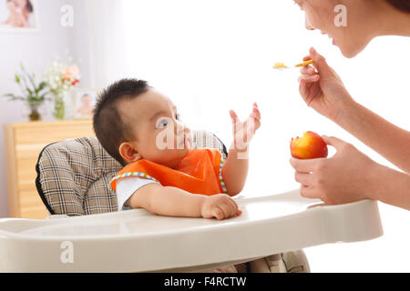 Mère nourrit le bébé à manger des fruits Banque D'Images