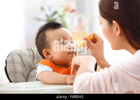 Mère nourrit le bébé à manger Banque D'Images