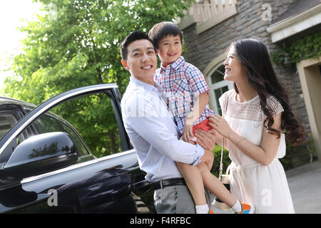 Famille heureuse debout à côté de la voiture Banque D'Images