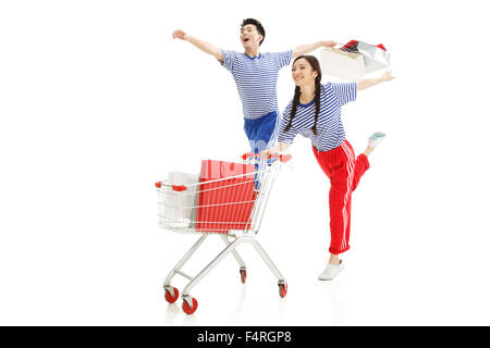 Happy young couple pousser un panier Banque D'Images