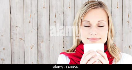 Image composite de portrait d'une jeune femme admirant son café chaud en hiver Banque D'Images